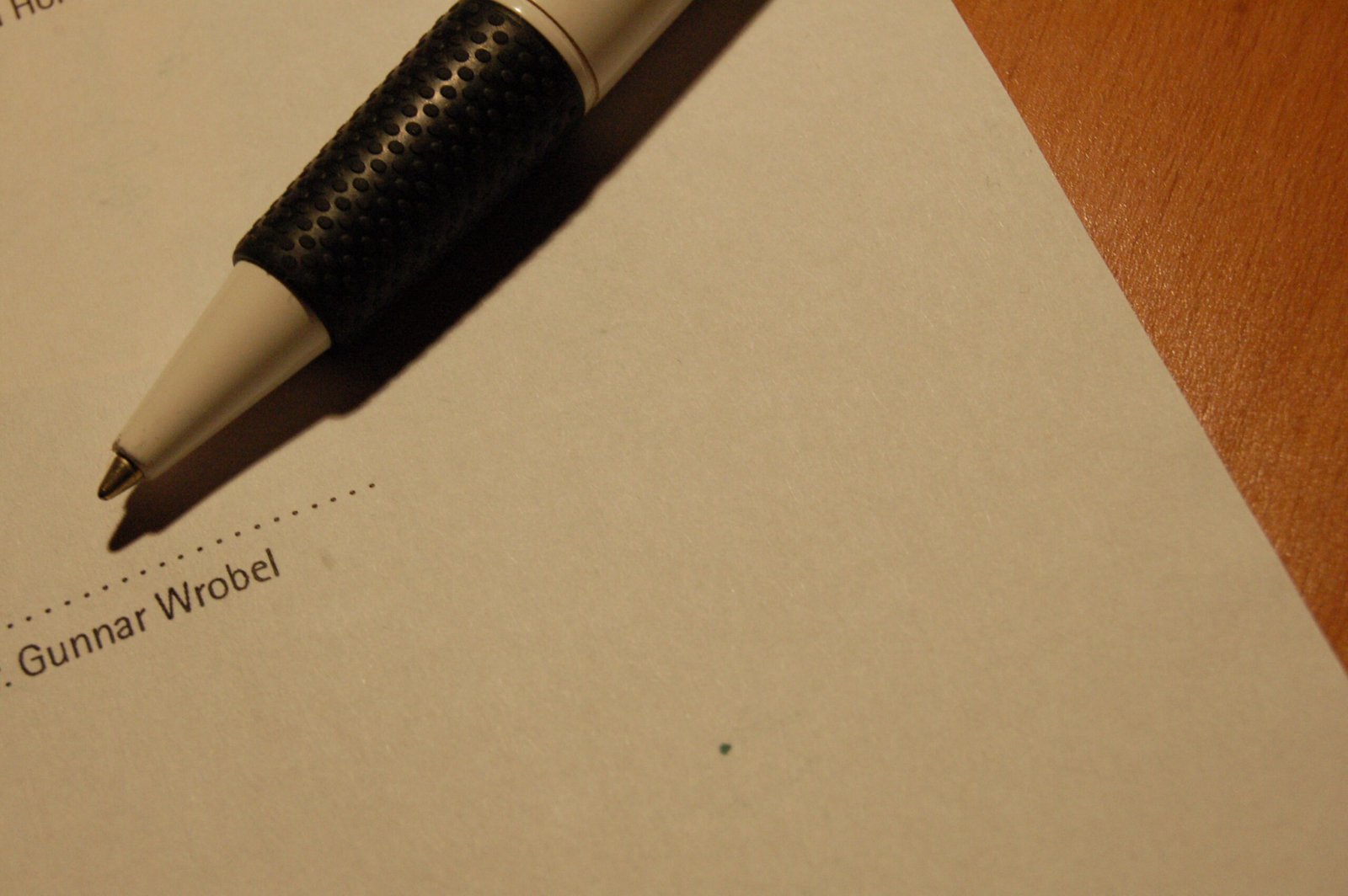 Contract document on a desk beside a pen
